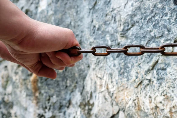 Abrazaderas de mano para cadenas a lo largo de pared de piedra — Foto de Stock