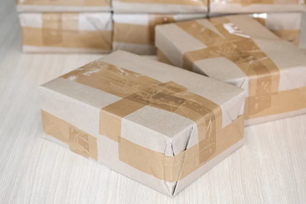 A few sealed packets in brown wrapping paper on the table — Stock Photo, Image