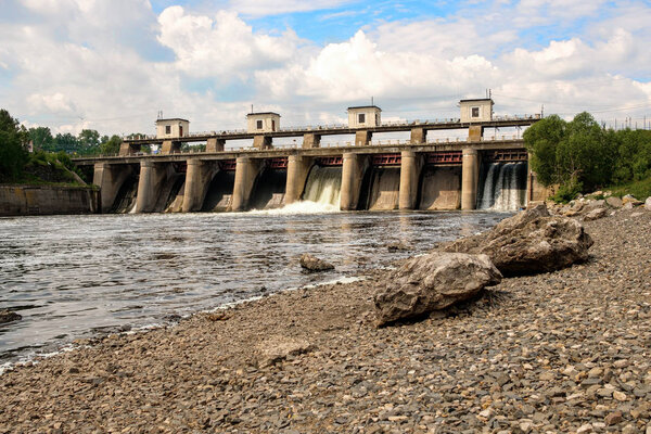 Дамба в летний день с падающей водой в замках
