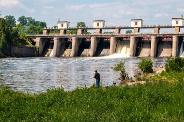 Barajın yanındaki nehirde balıkçı Mavi gökyüzü ve nehir