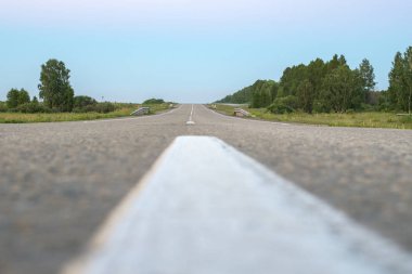 Yoldaki ayrım çizgisi beyazdır. Aşağıdan kaldırım döşenmiş yol manzarası.