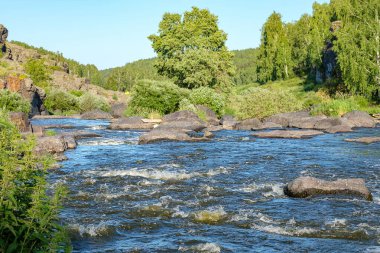 Çalkantılı yüzeyi ile bir dağ nehrinin sularının alçak bir noktasından manzara