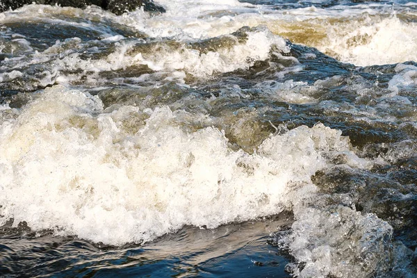 Dağ nehrinin hızlı akışı köpüklü ve köpüklü sarı su — Stok fotoğraf