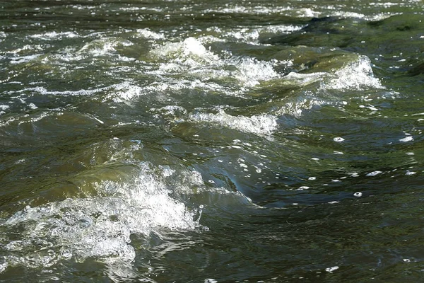 Acqua di un fiume di montagna con frangiflutti e onde — Foto Stock