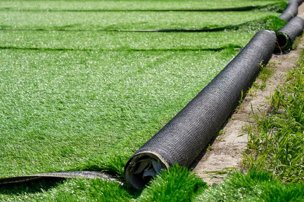 Green artificial covering of synthetic grass in rolls — Stock Photo, Image