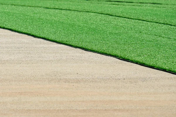 Installation of a new synthetic artificial grass covering on the field — 스톡 사진