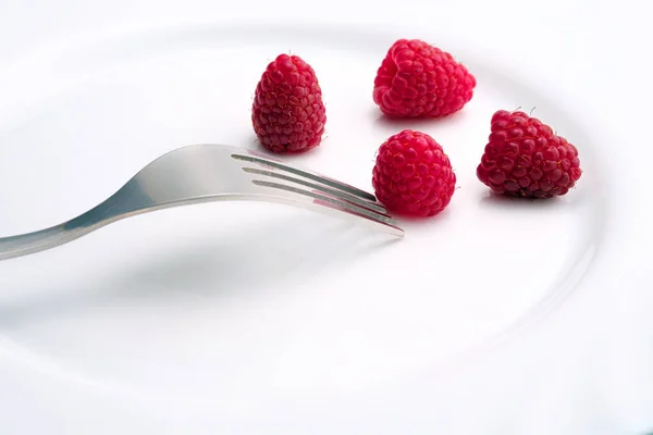 Unfocused Metal Fork Close Four Ripe Raspberries White Ceramic Surface — Stock Photo, Image