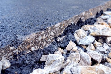 Üzerinde bir asfalt diliminin bulunduğu büyük çakıl taşı