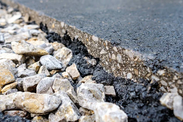 Ezilmiş taş ve ziftlerde bile bir parça asfalt görülebilir. yolları onar