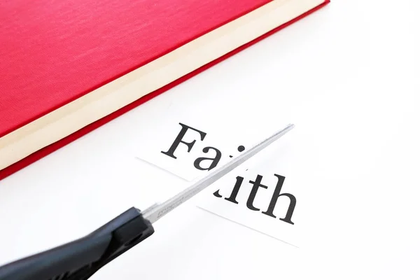the text on the piece of paper was cut in half at the red book scissors next to it. faith is over they don\'t believe anymore