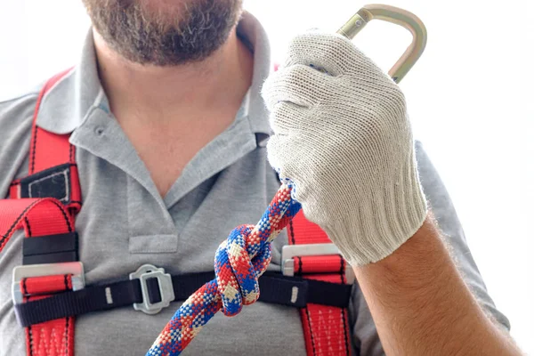 a rope in the hand of a man who is wearing equipment for working at height. occupational safety at work safe work