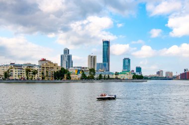 Rusya, Yekaterinburg, 14 Ağustos 2019. Bulutlu bir günde büyük bir şehirde, nehirde bir tekne yüzüyor. su seyahatleri