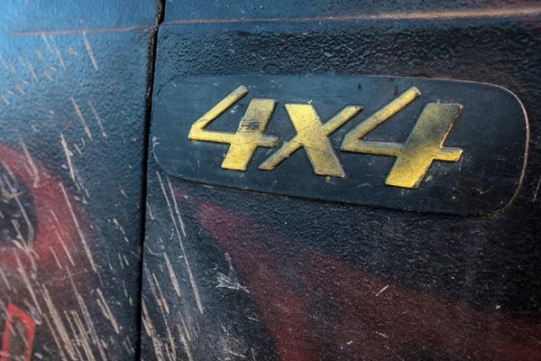 on the dirty car door, the four-wheel-drive symbol is two fours. dirty car after driving in the mud