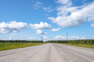Kenarında çarpık elektrik direklerinin olduğu eski yol. Yakında destek düşecek ve bir kaza olacak.