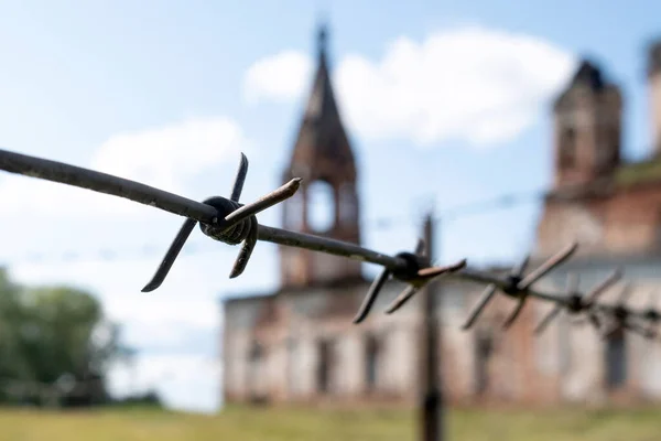 barbed wire on the background of an old building. fences near the old prison