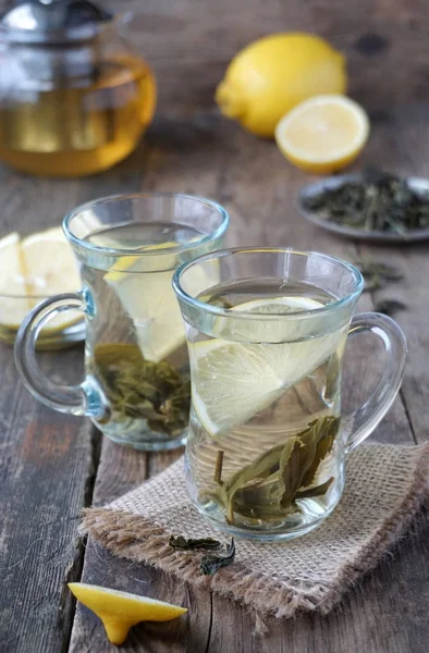 Hot green tea with lemon in glass mugs