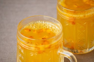 Kahverengi arka planda cam bardaklarda deniz dikenli çay.                                