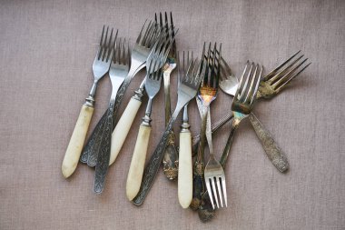 Kahverengi tekstil arka planında eski çatallar                                