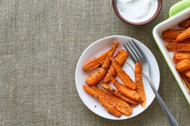 Beyaz tabakta dereotu tohumlu fırında havuç.                               