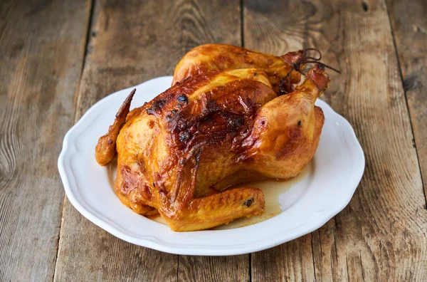 Eski ahşap arka planda tam pişmiş tavuk.                               