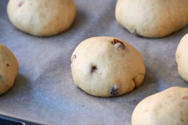 Kağıt üzerinde kuru üzümlü çiğ çörekler.                               