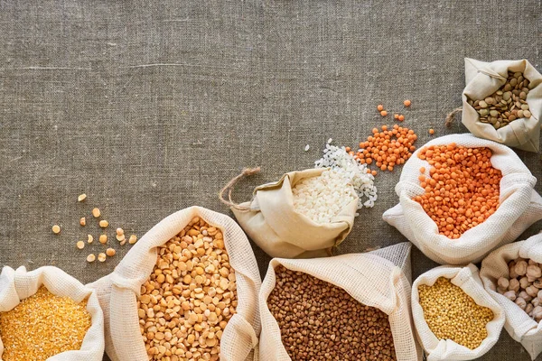 Tekstil arka planında pamuk torbalarında çeşitli taneler                               