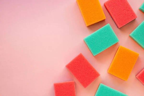 ピンク色の背景に皿を洗うためのスポンジ — ストック写真