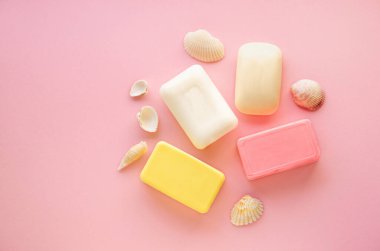 Pembe arka planda çeşitli sabunlar.