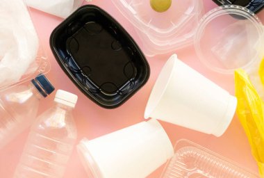 Pembe arka planda çeşitli plastik atık