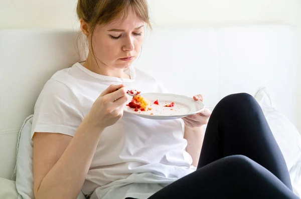 Chica Triste Sentada Cama Comiendo Pastel — Foto de Stock