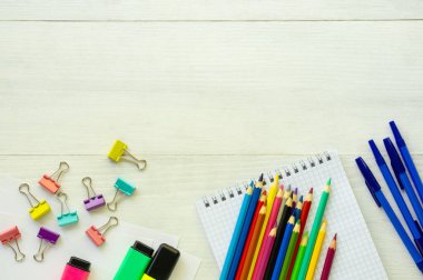 Beyaz ahşap arka planda okul malzemeleri.