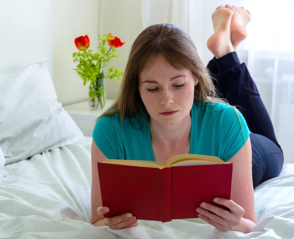 Серьёзная Молодая Женщина Лежит Дома Кровати Читает Книгу — стоковое фото