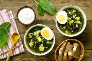 Külüstür yeşil çorba, ahşap zemin üzerinde yumurta ve patates.