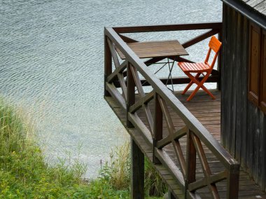 Turuncu bir sandalye ve bir Balkonda duran bir tablo