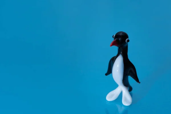 Estatueta de vidro de um pinguim pequeno bonito com um bico vermelho — Fotografia de Stock