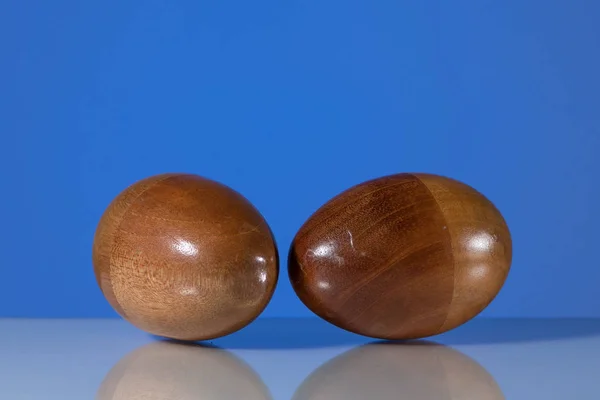 Two wooden egg shaker in front of a blue background — Stock Photo, Image