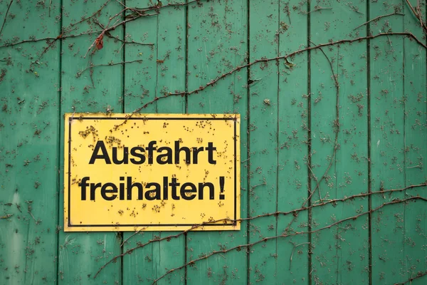 Желтый знак с немецкой надписью "Держите выход свободным — стоковое фото