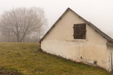 Kış sisli bir günde evde yaşlı çiftçinin