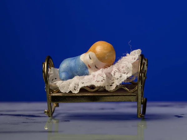 बिस्तर पर सोने वाले बच्चे की एक छोटी मूर्ति का क्लोजअप — स्टॉक फ़ोटो, इमेज