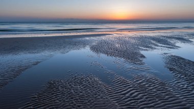 Sunrise Omaha Beach Normandiya Fransa alçak bulutlar ile