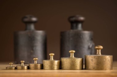 Old iron 1kg weights and smaller brass weights for a kitchen scale clipart