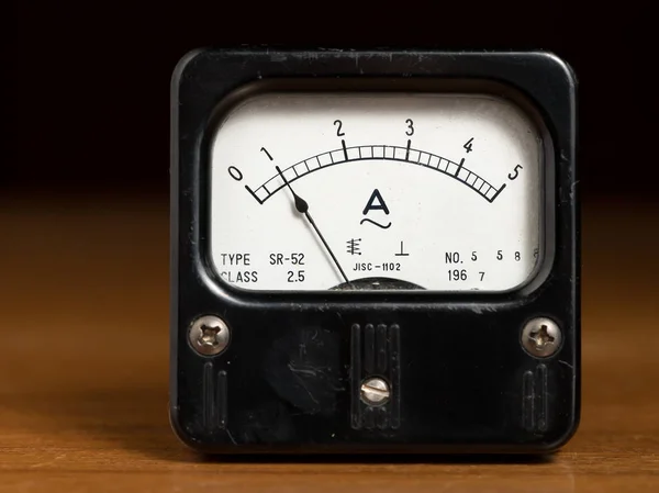 Ein altes schwarzes analoges Ampere-Messgerät auf einem Holztisch — Stockfoto