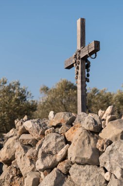 Taştan bir duvar küçük ahşap çarmıhta asılı tespih