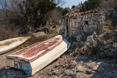 Ustrine yakınındaki bir koyda eski taş evin önünde yalan tekne