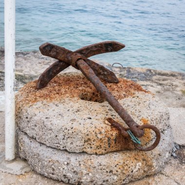 Yuvarlak bir taş üzerinde yalan küçük paslı çapa