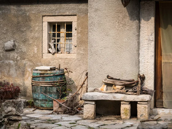 Βαρελίσιο κρασί και πέτρινο πάγκο μπροστά από ένα παλιό σπίτι στο Valun — Φωτογραφία Αρχείου