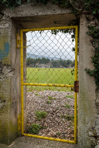 Pequeña puerta amarilla de hierro, entrada a un campo de fútbol — Foto de Stock