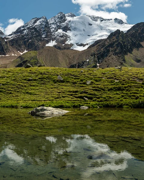 Vallée et montagnes près de Melago par une journée ensoleillée en été, reflet dans l'étang — Photo