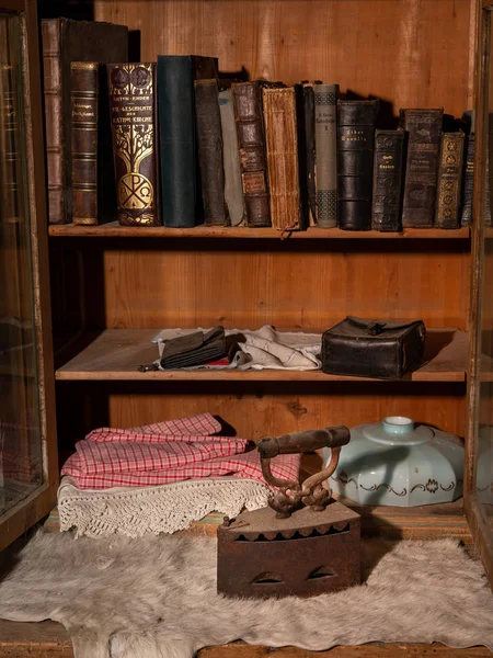 Ένα παλιό σκουριασμένο σίδερο και βιβλία σε ένα ράφι. — Φωτογραφία Αρχείου