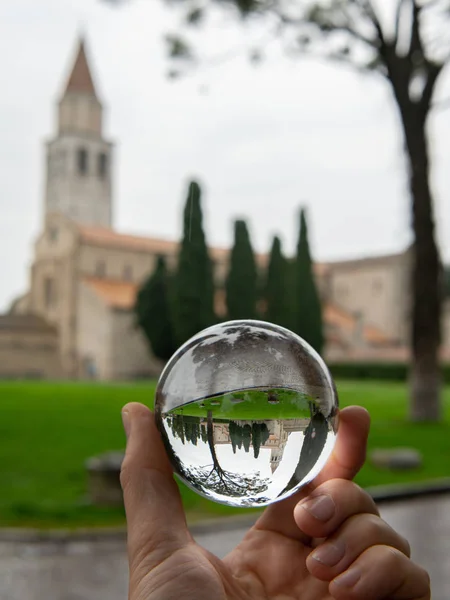 La cattedrale di Aquileia attraverso la sfera di vetro in una giornata nuvolosa nel tardo autunno — Foto Stock